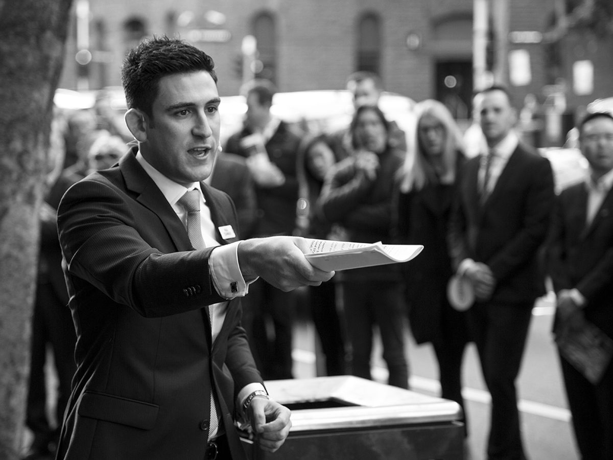 Auctioneer briefing a vendor before a Melbourne auction